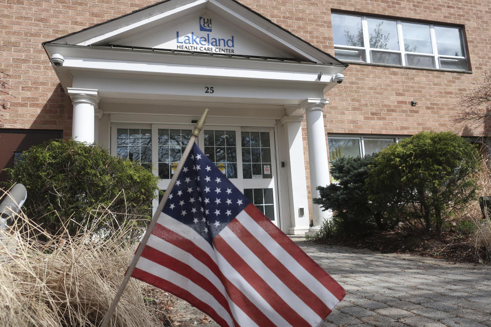 FILE - This Wednesday, April 1, 2020, file photo, shows an entrance to the Lakeland Health Care Center, a nursing home in Wanaque, N.J. Multiple people at the facility have died of COVID-19, the disease caused by the new coronavirus, according to the borough's Mayor Dan Mahler. Several others, including residents and staff members, are infected. After two months and 10,000 deaths that have made the nation’s nursing homes the worst places to be during the coronavirus crisis, most of them still don’t have access to enough tests to help control outbreaks among their frail, elderly residents. (AP Photo/Ted Shaffrey, File)