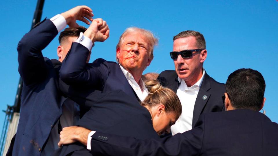 Former President Donald Trump is surrounded by Secret Service agents at a campaign rally in Butler, Pa, on Saturday, July, 13, 2024. Trump was escorted off the stage by Secret Service agents and into his motorcade just minutes into his rally in Butler, Pa., on Saturday, after a series of pops that sounded like gunshots rang out. (Doug Mills/The New York Times)
