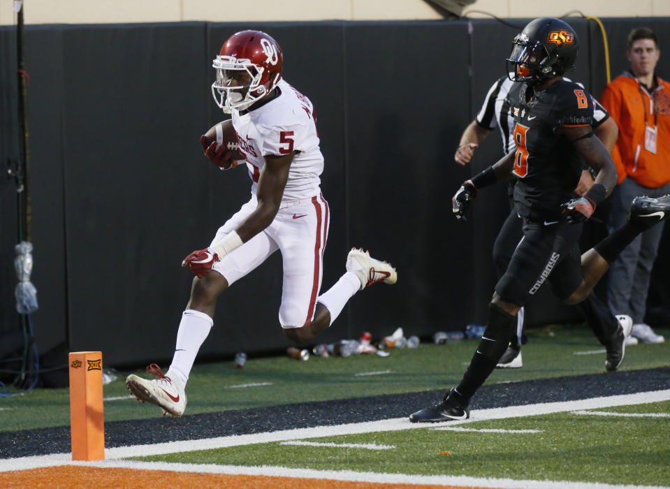 Oklahoma wide receiver Marquise Brown (5)t scores in front of Oklahoma State cornerback Rodarius Williams (8) in Stillwater, Okla., Saturday, Nov. 4, 2017. (AP Photo/Sue Ogrocki)