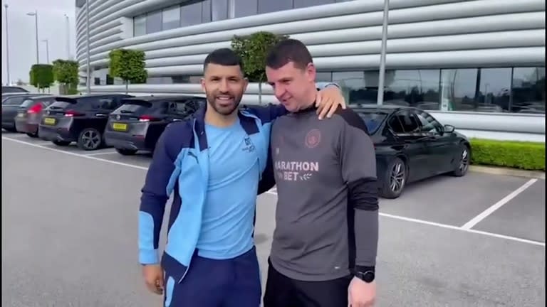 Sergio Agüero posa con el ganador del sorteo de su camioneta Range Rover, en el centro de entrenamientos de Manchester City.