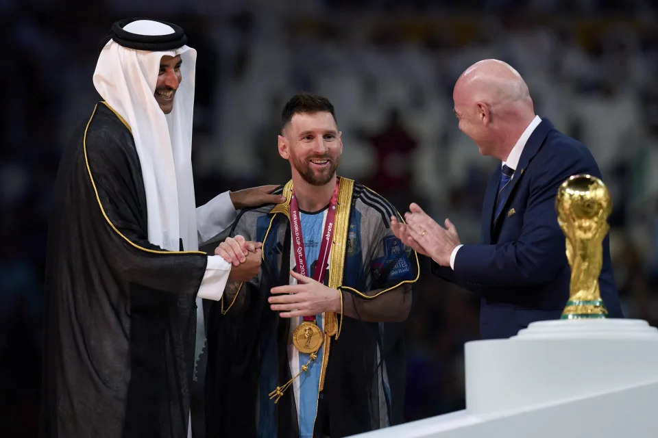 Argentina captain Lionel Messi is presented with a black bisht from Emir of Qatar Tamim Hamad Al Thani (left) and Fifa president Gianni Infantino (right) before receiving the World Cup trophy. 