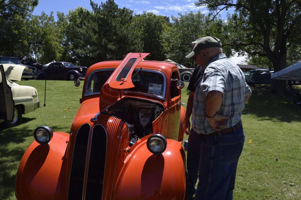 A custom car enthusiast looks at a 1948 Ford English Thames owned by Larry Cottam (background) at the KKOA Leadsled Spectacular. Cottam, who lives in Salina, bought the car a little over a year ago.