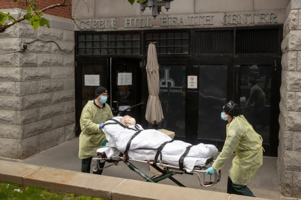 Emergency medical technicians wheel a patient out of the Cobble Hill Health Center in New York in April. A report from the New York State Attorney General says the state government undercounted deaths in nursing homes by as much as 50 per cent. 