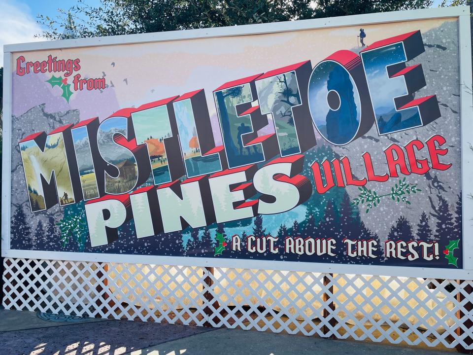 sign outside of mistletoe pines village universal orlando christmas event