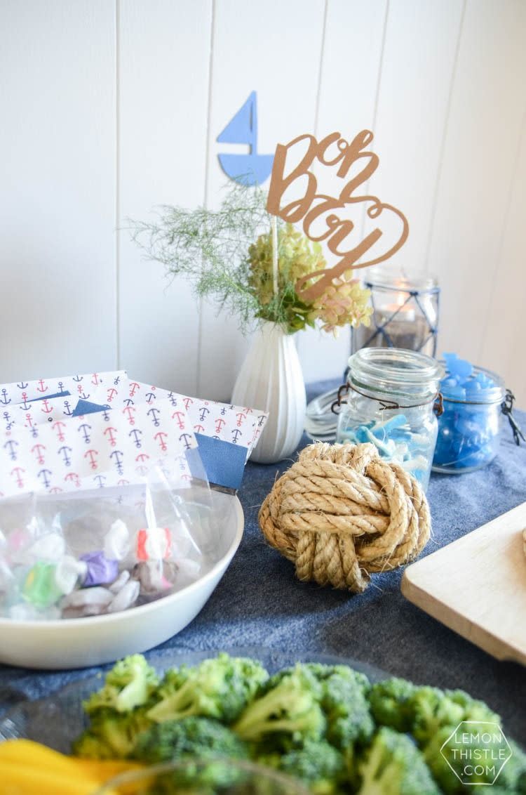 a nautical themed party table with a rope knot, oh boy sign and blue accents