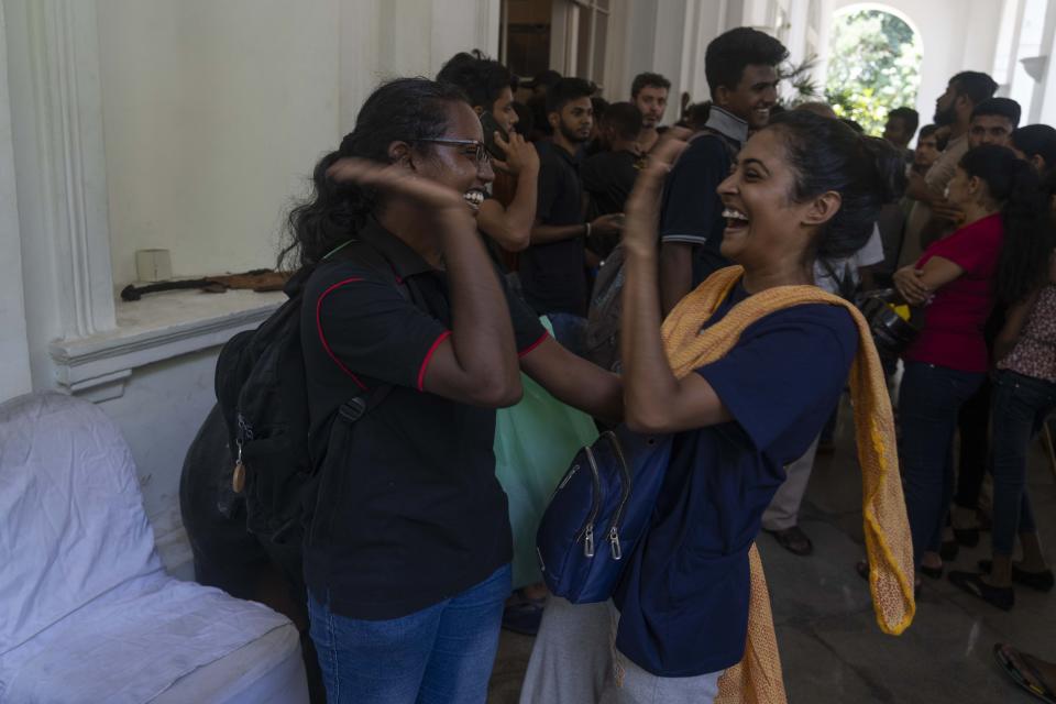 Protesters cheer as they vacate the President Gotabaya Rajapaksa's official residence in Colombo, Sri Lanka, Thursday, July 14, 2022. Protest leader Devinda Kodagode told The Associated Press they were vacating official buildings after the Parliament speaker said he was seeking legal options to consider since Rajapaksa left without submitting his resignation letter as promised. (AP Photo/Rafiq Maqbool)