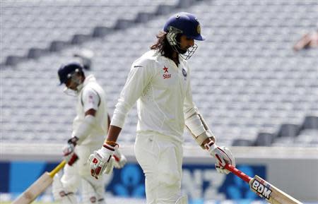 India's Ishant Sharma departs for no score and Mohammed Shami (L) comes in as India's last batsman on day three of the first international test cricket match against New Zealand at Eden Park in Auckland, February 8, 2014. REUTERS/Nigel Marple