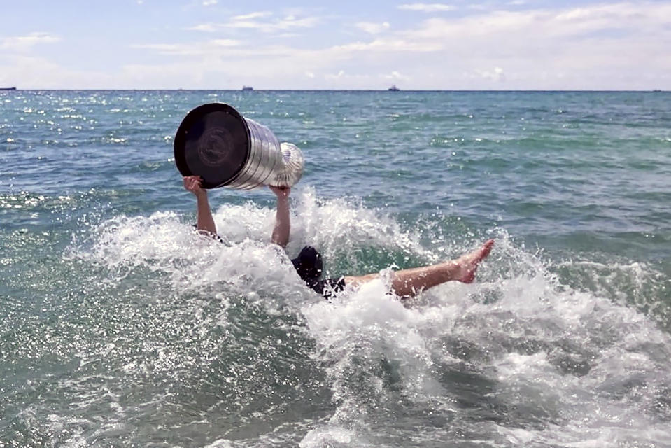 Florida Panthers NHL hockey player Matthew Tkachuk takes the Stanley Cup into the Atlantic Ocean in Fort Lauderdale, Fla., Tuesday, June 25, 2024. The Panthers beat the Edmonton Oilers 2-1 on Monday night in Game 7 of the Stanley Cup Final. (Joe Cavaretta/South Florida Sun-Sentinel via AP)