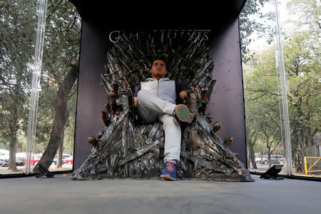 FILE PHOTO: A visitor poses for a photograph as he sits on a replica of the iron throne, as part of the promotion of the final season of "Game of Thrones" in Mexico City, Mexico April 10, 2019. REUTERS/ Carlos Jasso