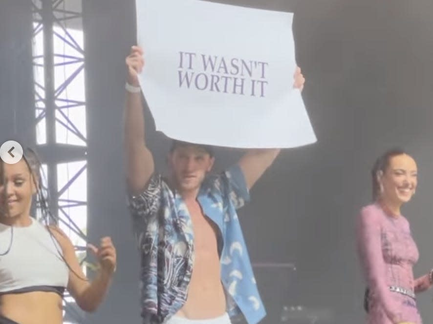 A picture of Paul holding a sign on stage with O'Brien