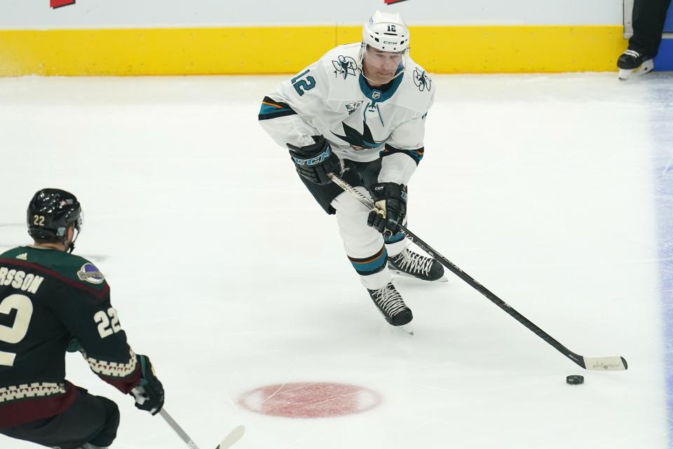 San Jose Sharks left wing Patrick Marleau (12) handles the puck in front of Arizona Coyotes left wing Johan Larsson (22) during the first period of an NHL hockey game Thursday, Jan. 14, 2021, in Glendale, Ariz. (AP Photo/Ross D. Franklin)