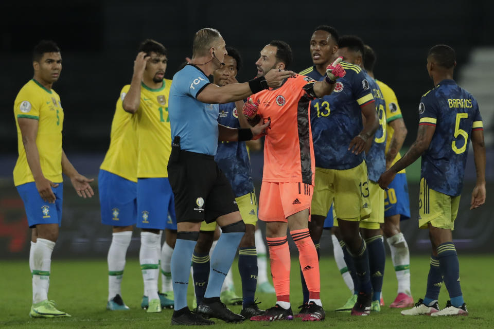 Colombia's goalkeeper David Ospina, center, complains to Referee Nestor Pitana, of Argentina, during a Copa America soccer match against Brazil at Nilton Santos stadium in Rio de Janeiro, Brazil, Wednesday, June 23, 2021. (AP Photo/Silvia Izquierdo)