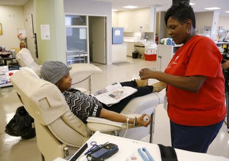 Technician Nikki Boyce (R) prepares to draw blood from donor Jacqueline Carr (L) of Washington at the American Red Cross Charles Drew Donation Center in Washington February 16, 2016. REUTERS/Gary Cameron