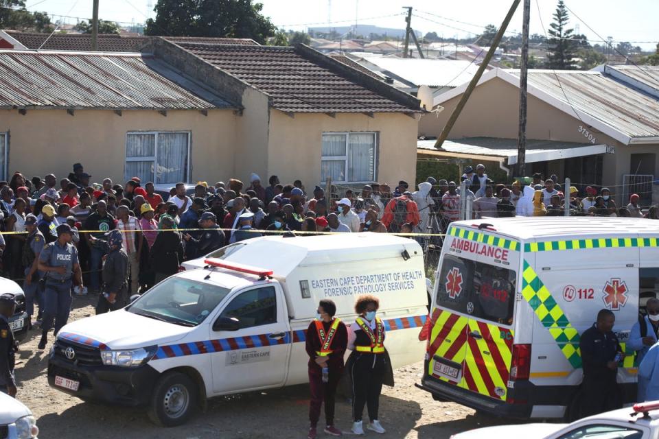 A crowd gathers as forensic personnel investigate after the deaths of patrons of the Enyobeni Tavern (Reuters)