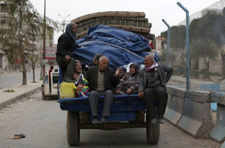 People ride in a truck with their belongings in the center of Afrin, Syria March 24, 2018. REUTERS/Khalil Ashawi