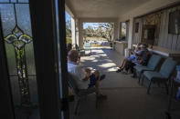 Parishioners chat on the patio at the Southwest Baptist Church in Fort Myers, Fla., Sunday, Oct. 2, 2022. Nearly a dozen are sleeping in the church's sanctuary after their homes were destroyed by Hurricane Ian. (AP Photo/Robert Bumsted)