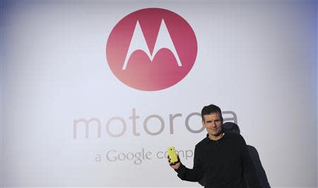 Motorola Mobility Chief Executive Dennis Woodside poses with the new Moto G mobile phone during its worldwide presentation in Sao Paulo November 13, 2013. REUTERS/Nacho Doce