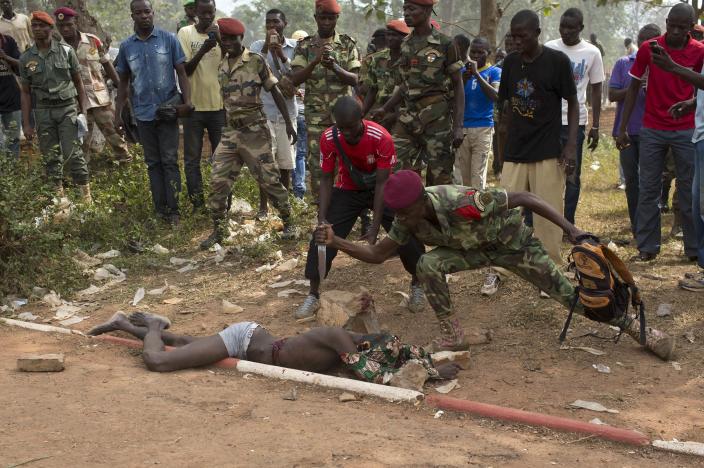 ATTENTION EDITORS - VISUAL COVERAGE OF SCENES OF INJURY OR DEATH RNPS - REUTERS NEWS PICTURE SERVICE - PICTURES OF THE YEAR 2014 A Central African Army (FACA) soldier stabs the corpse of a man, who was killed after he was accused of joining the ousted Seleka fighters, in the capital Bangui, in this February 5, 2014 file photo. REUTERS/Siegfried Modola/Files (CENTRAL AFRICAN REPUBLIC - Tags: POLITICS CIVIL UNREST MILITARY TPX IMAGES OF THE DAY) TEMPLATE OUT