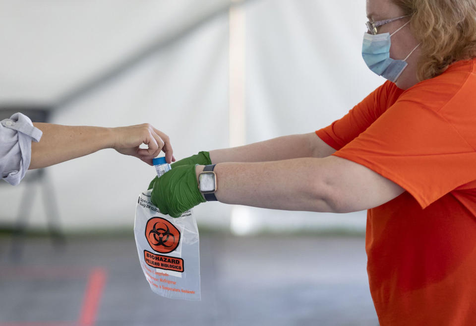 A COVID-19 saliva sample is collected as testing is conducted on July 7, 2020, in a tent on the University of Illinois at Urbana-Champaign campus. (Photo: Brian Cassella/Chicago Tribune/TNS)