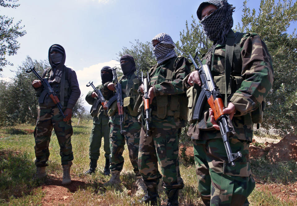 In this Friday, April 12, 2013 photo, Hezbollah fighters stand guard at the Lebanon-Syria border, near the northeastern Lebanese town of al-Qasr, Lebanon. The Shiite group has sent hundreds of its fighters into Syria to shore up President Bashar Assad’s overstretched troops, helping them gain ground around the capital, Damascus, and near the Lebanese border. The Shiite group has sent hundreds of its fighters into Syria to shore up President Bashar Assad’s overstretched troops, helping them gain ground around the capital, Damascus, and near the Lebanese border. But with its own casualties mounting in a civil war that activists say has killed more than 150,000 people in three years, officials say Hezbollah has turned to a variety of new tactics - including complicated commando operations - to hunt down rebels and opposition commanders. (AP Photo/Bilal Hussein)