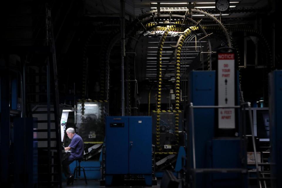 Pressman Mike Carper reviews newspapers at the press console at the Olympic plant.