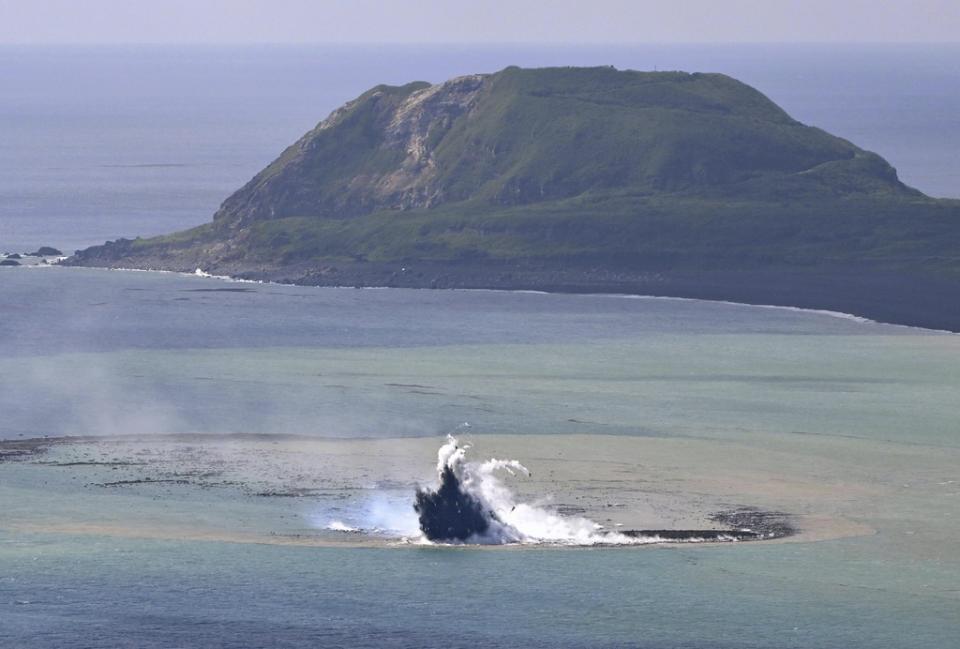 This aerial photo shows steam billowing from the waters off Iwoto Island, Ogasawara town in the Pacific Ocean, southern Tokyo, on Oct. 30, 2023. A new island, 100 meters in diameter, formed by erupted rock, is seen near the steam, according to Kyodo News. (Kyodo News via AP)