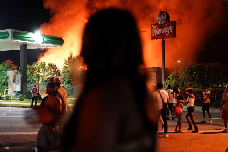 FILE PHOTO: People watch as a Wendy’s burns following a rally against racial inequality and the police shooting death of Rayshard Brooks, in Atlanta