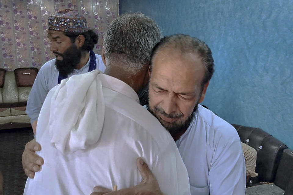 People offer their support to Raja Yousaf, right, whose son Raja Sajid is missing after a shipwreck off the Greek coast, in Bindian village in Kotli, a district of Pakistan's administrator Kashmir, Sunday, June 18, 2023.  / Credit: Nasir Mehmood / AP