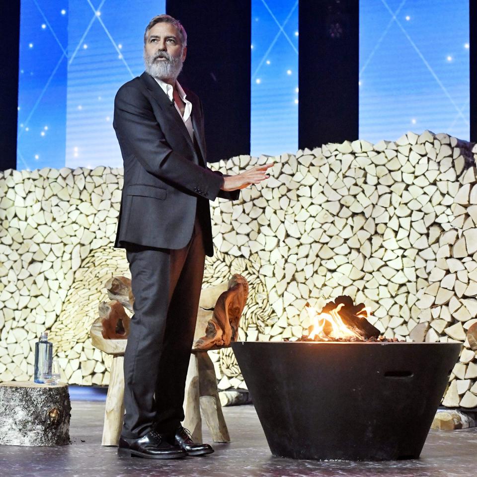 George Clooney warms himself up while speaking at the Nordic Business Forum seminar in Helsinki, Finland, on Thursday.