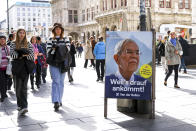 People walk past an election campaign poster of current federal president Alexander Van der Bellen in Vienna, Austria, Thursday, Sept. 29, 2022. Austrian voters will head to the polls Sunday, Oct. 9, 2022, in the first round of the country's presidential election. (AP Photo/Theresa Wey)