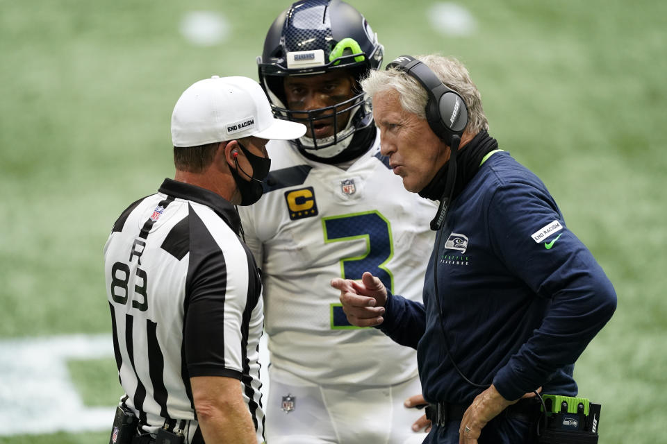 Seattle Seahawks quarterback Russell Wilson (3) and Seattle Seahawks head coach Pete Carroll speak to back judge Shawn Hochuli (83) during the first half of an NFL football game against the Atlanta Falcons, Sunday, Sept. 13, 2020, in Atlanta. (AP Photo/John Bazemore)