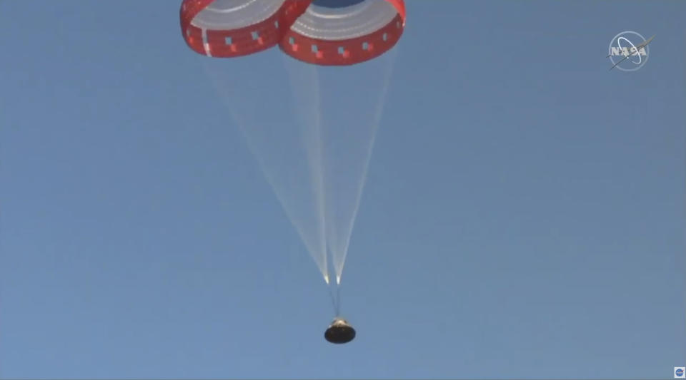 In this image made from a video provided by NASA parachutes guide the Starliner capsule to the ground after a test of Boeing's crew capsule's launch abort system in White Sands Missile Range in N.M., on Monday, Nov. 4, 2019. The capsule carried no astronauts Monday morning, just a test dummy. (NASA via AP)