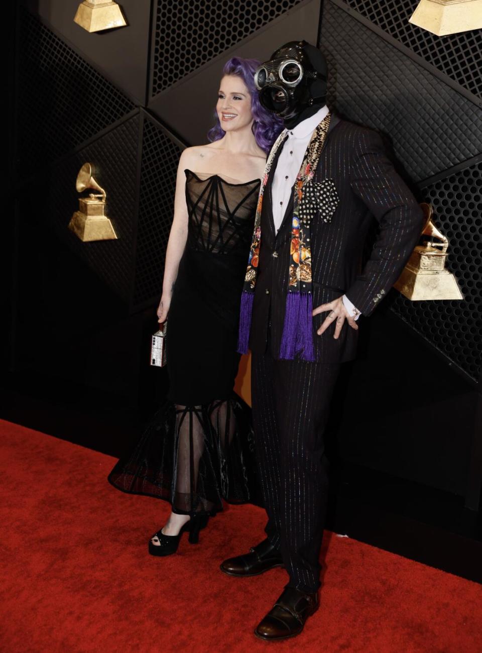 Kelly Osbourne in a black gown and Slipknot's Sid Wilson in a steampunk submarine mask.