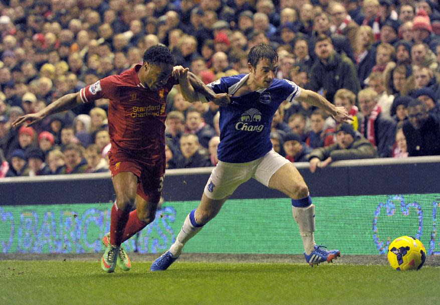 Liverpool's Raheem Sterling, left, tackles Everton's Leighton Baines during their English Premier League soccer match at Anfield in Liverpool, England, Tuesday Jan. 28, 2014. (AP Photo/Clint Hughes)