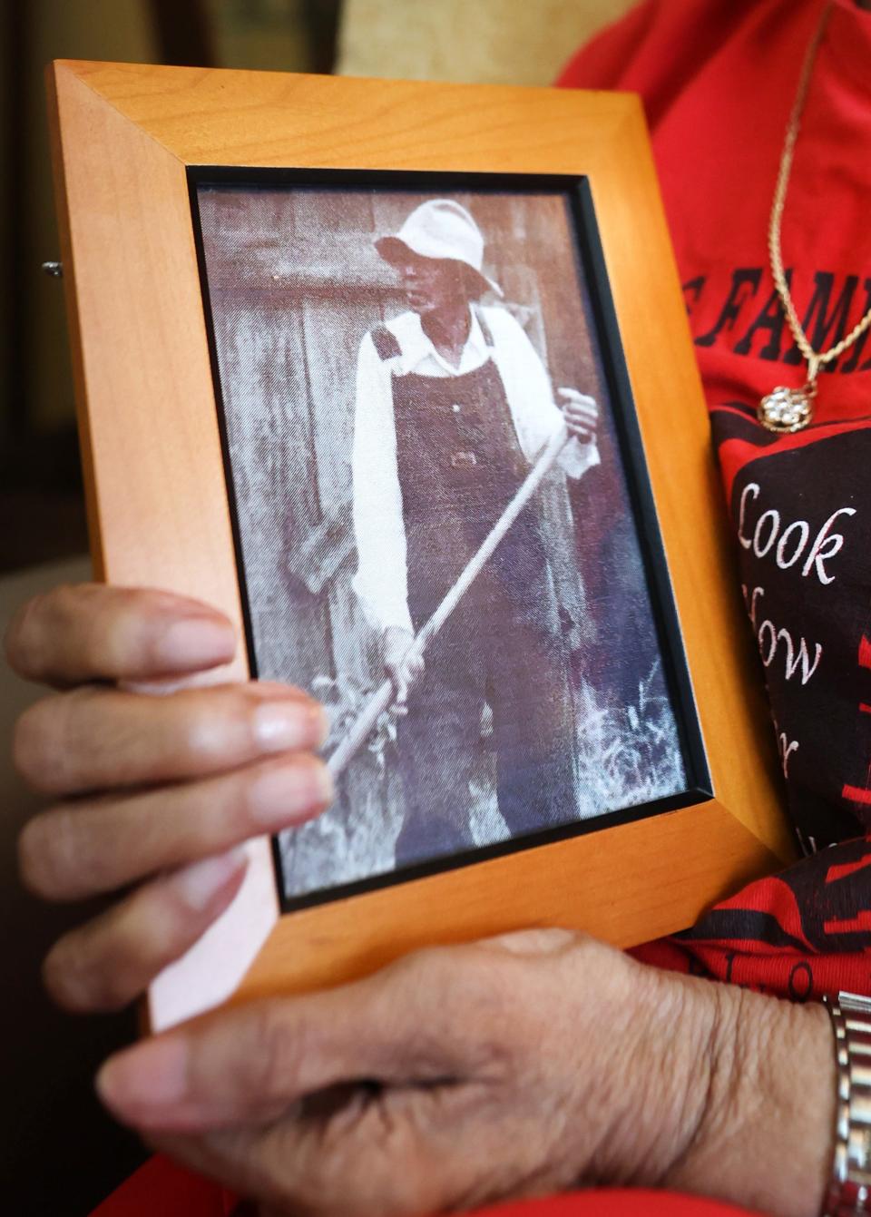 Ora Jackson holds a photo of her father Virge Cooley.