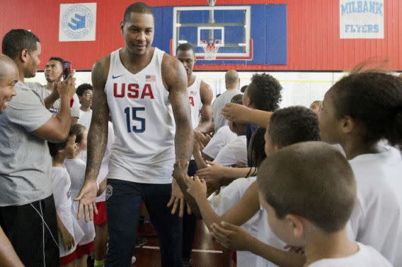 The U.S. men’s Olympic basketball team player Carmelo Anthony greets children that participated in a basketball clinic as he arrives for a news conference Monday, June 27, 2016, in New York. (AP Photo/Mary Altaffer)