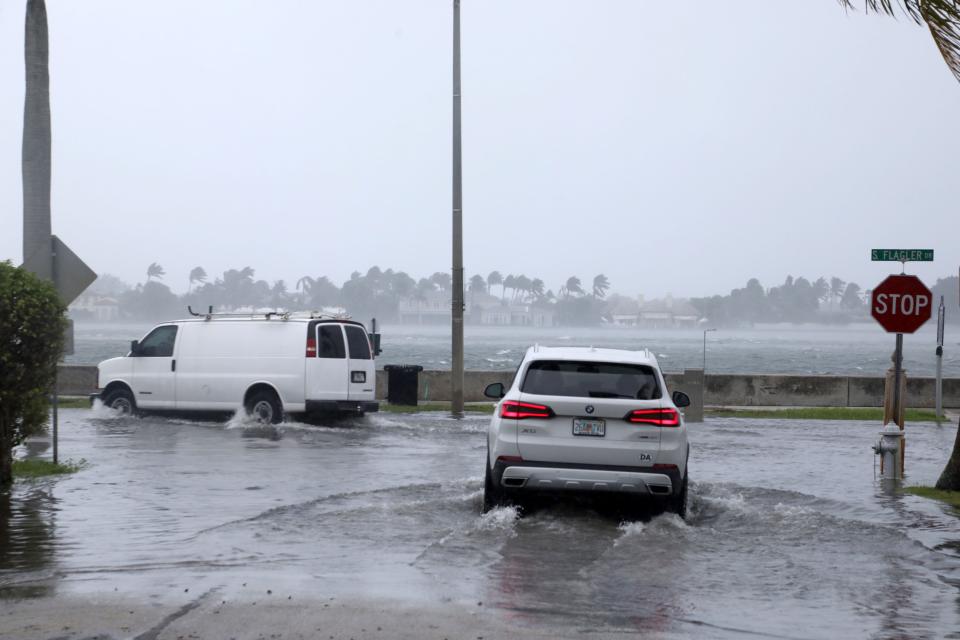 Cars turn off of Persian Way onto a flooded Flagler Drive as Tropical Storm Nicole approaches on Wednesday.