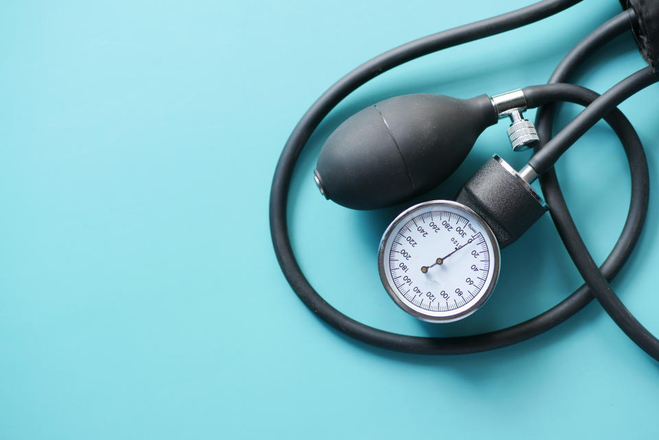 Sphygmomanometer with pump and gauge on a blue background