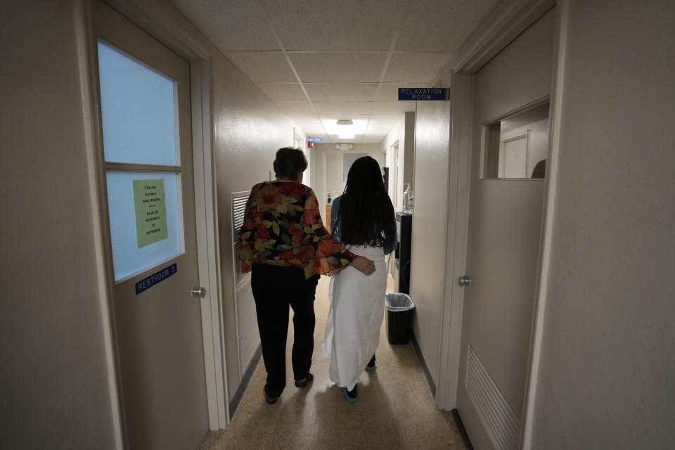 FILE - A 33-year-old mother of three from central Texas is escorted down the hall by clinic administrator Kathaleen Pittman prior to getting an abortion, Oct. 9, 2021, at Hope Medical Group for Women in Shreveport, La. Reproductive rights advocates are planning to open new abortion clinics or expand the capacity of existing ones in states without restrictive abortion laws. (AP Photo/Rebecca Blackwell, File)