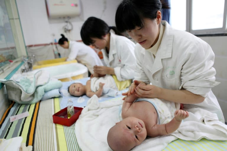 Nurses massage babies at an infant care centre in Yongquan, in Chongqing municipality, in southwest China