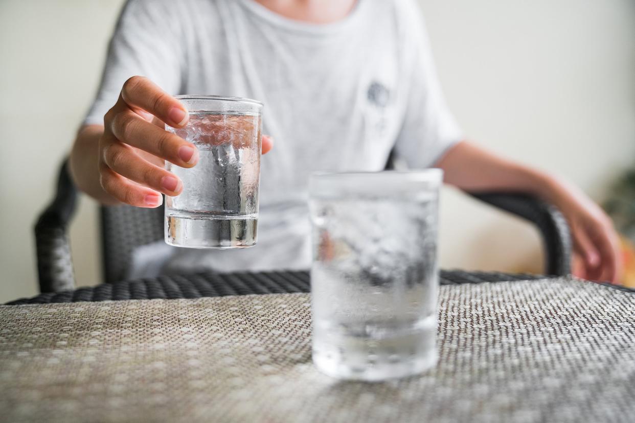 glass of very cold water in girl's hand transparent glass