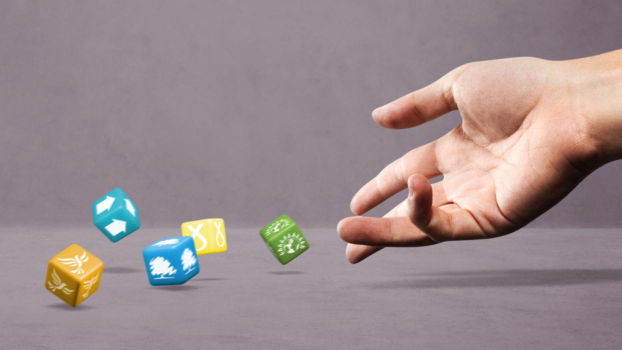  Hand rolling dice marked with logos of British political parties, including Conservative, Green, Reform UK, SNP and Liberal Democrat. 