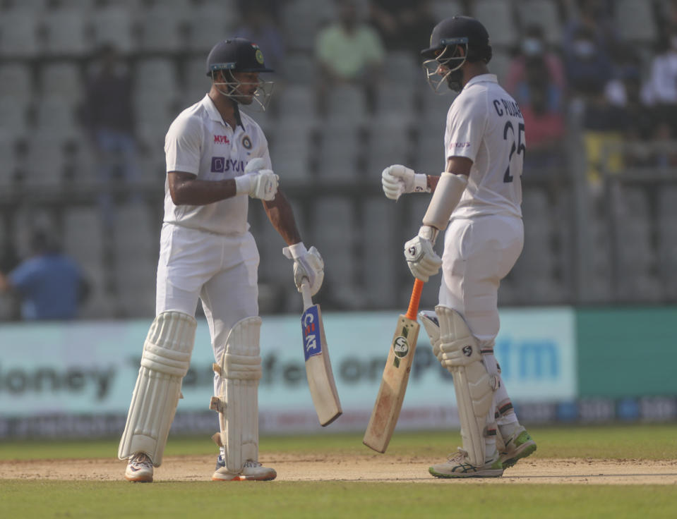 India's Cheteshwar Pujara , right, along with Mayank Agarwal looks on during the day three of their second test cricket match with New Zealand in Mumbai, India, Sunday, Dec. 5, 2021.(AP Photo/Rafiq Maqbool)