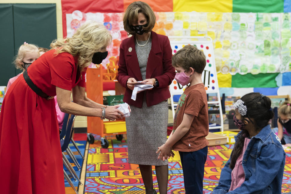First lady Jill Biden is presented with a Rubik's Cube origami by fourth grade student Dennis Larson during a visit to a pediatric COVID-19 vaccination clinic at Franklin Sherman Elementary School in McLean, Va., with Surgeon General Dr. Vivek Murthy, to kick off a nationwide effort urging parents and guardians to vaccinate kids ages 5 to 11, Monday, Nov. 8, 2021. (AP Photo/Manuel Balce Ceneta)
