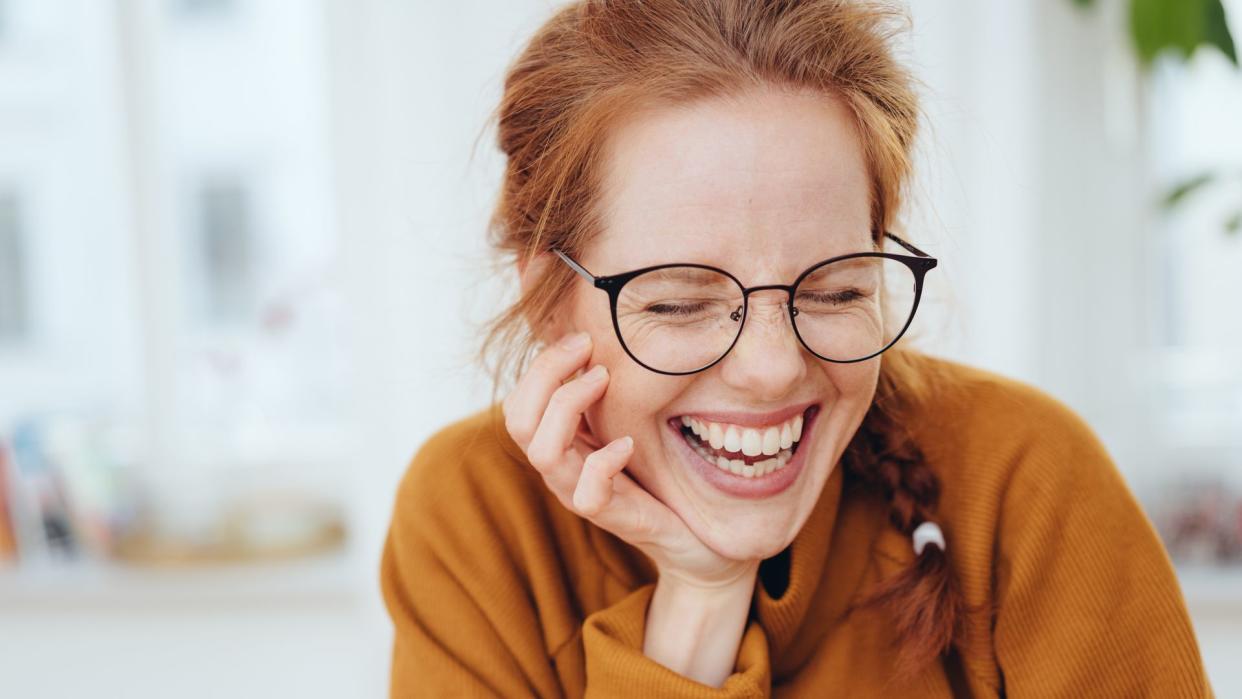 mujer pelirroja sonriente con gafas