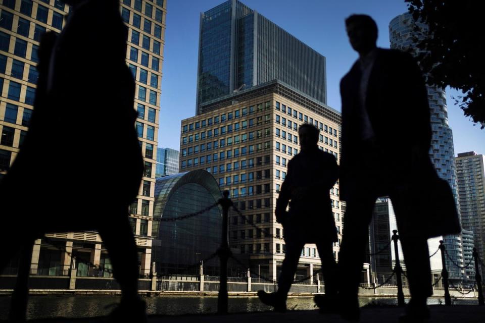 Office workers and commuters walking through Canary Wharf in London during the morning rush hour (PA) (PA Wire)