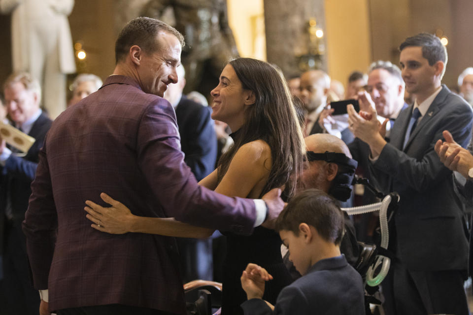 Saints quarterback Drew Brees congratulates Steve Gleason and his wife Michel Gleason, during a Congressional leadership and other members of Congress at a Congressional Gold Medal ceremony honoring amyotrophic lateral sclerosis (ALS) advocate and former National Football League (NFL) player, Steve Gleason, in Statuary Hall on Capitol Hill, Wednesday, Jan. 15, 2020, in Washington. (AP Photo/Manuel Balce Ceneta)