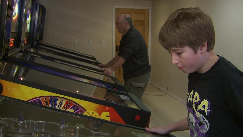 Escher and Adam play pinball together at their home (FOX31 Denver/KDVR)