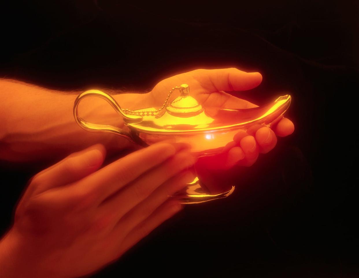 person rubbing magic lamp to conjure genie