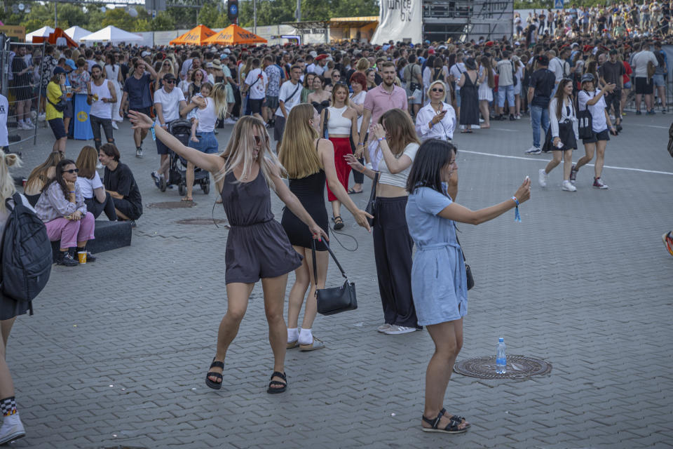 Personas bailan esperando el comienzo del Festival Atlas en Kiev, Ucrania, el domingo 21 de julio de 2024. Este año, el festival de música más grande de Ucrania tocó una fibra sensible diferente. Atrás quedaron los artistas internacionales, los enormes escenarios y los cientos de miles de visitantes. (Foto AP/Anton Shtuka)
